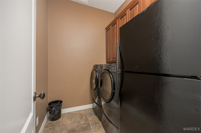 clothes washing area featuring stone finish floor, cabinet space, baseboards, and independent washer and dryer