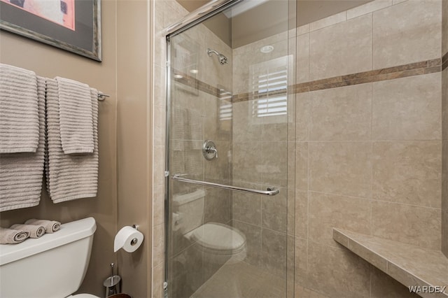 full bathroom with tiled shower and toilet