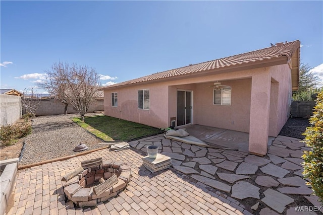 rear view of house with a patio area, stucco siding, a fire pit, and ceiling fan