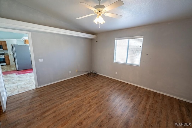 spare room featuring baseboards, lofted ceiling, a ceiling fan, and wood finished floors