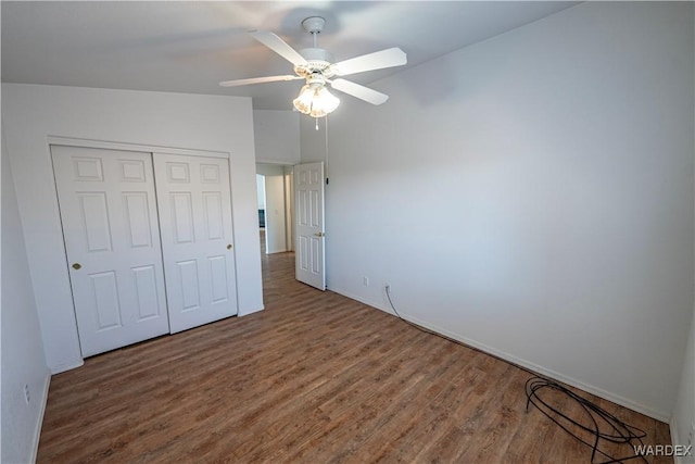 unfurnished bedroom with wood finished floors, a closet, and ceiling fan