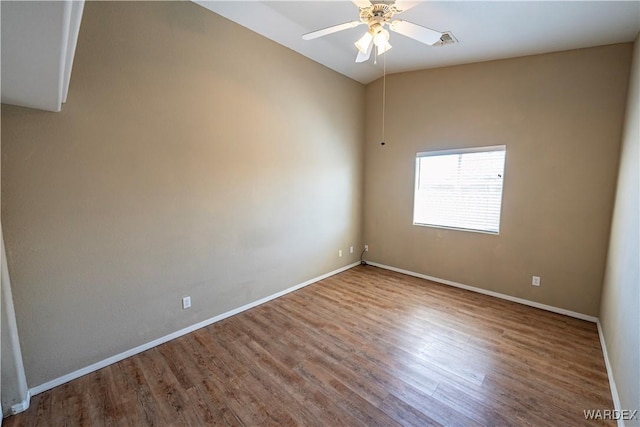 empty room featuring visible vents, ceiling fan, baseboards, and wood finished floors