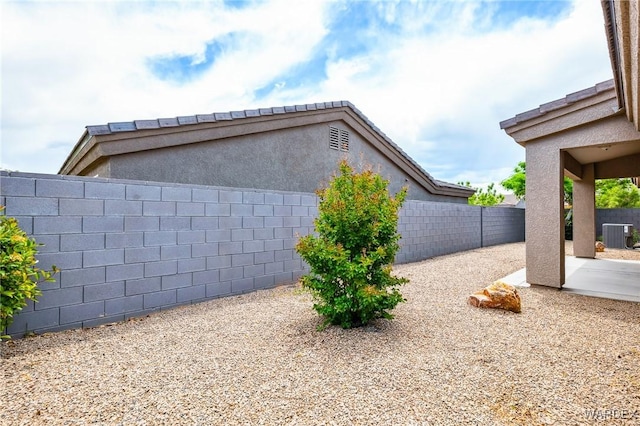 exterior space with a fenced backyard, a patio, and central air condition unit