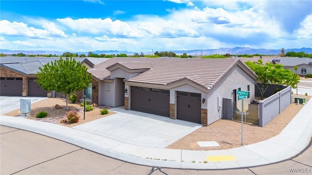 single story home with stucco siding, an attached garage, fence private yard, and a mountain view