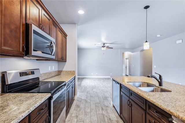 kitchen featuring a sink, stainless steel appliances, decorative light fixtures, light wood-type flooring, and a ceiling fan