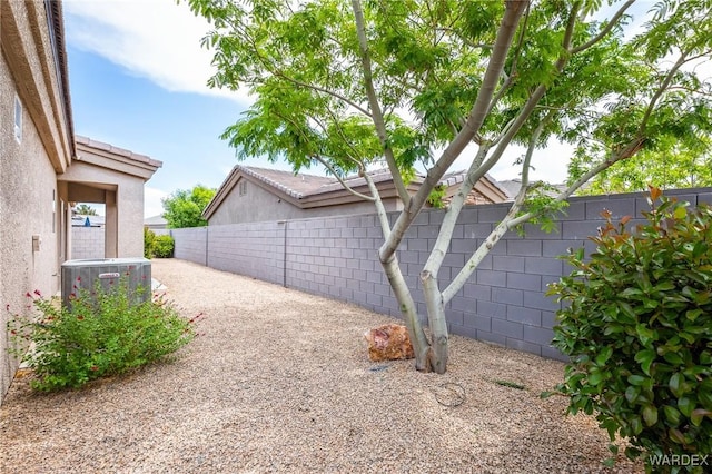 exterior space with central AC, stucco siding, and a fenced backyard