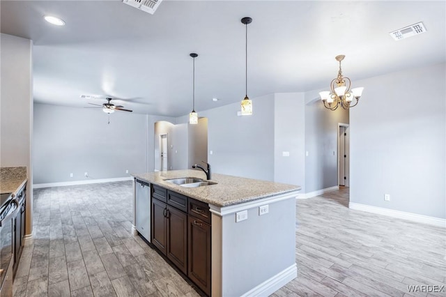 kitchen featuring a sink, open floor plan, light wood-style floors, and appliances with stainless steel finishes