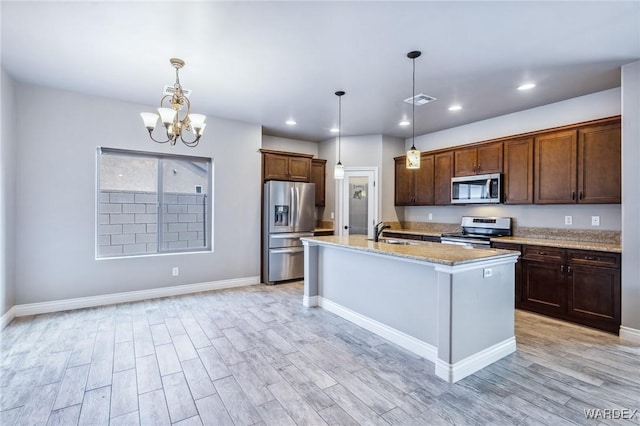 kitchen with light wood finished floors, appliances with stainless steel finishes, a chandelier, and a sink