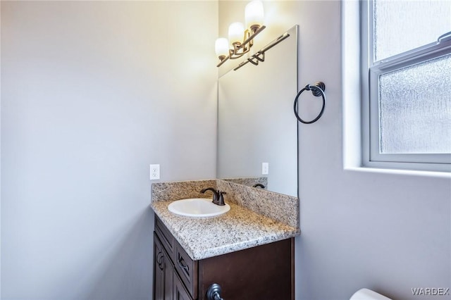 bathroom with an inviting chandelier and vanity