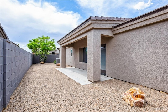 back of house with cooling unit, stucco siding, a patio area, and a fenced backyard