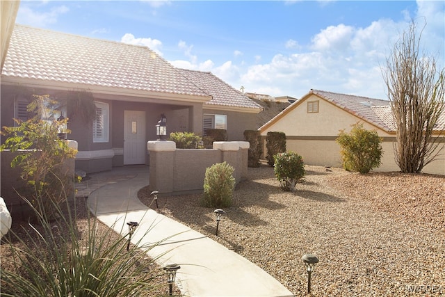 view of front of home featuring a tiled roof and stucco siding