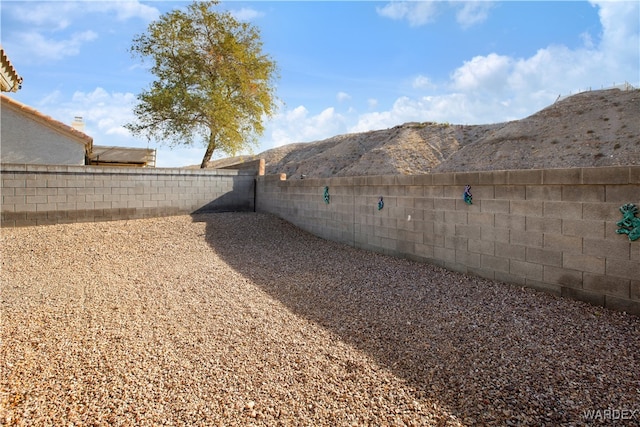 view of yard with a fenced backyard and a mountain view