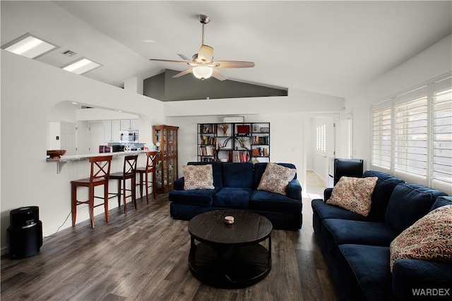 living area featuring dark wood-style floors, lofted ceiling, visible vents, and a ceiling fan