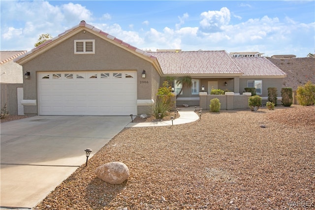 view of front of house with driveway, stucco siding, an attached garage, and a tiled roof