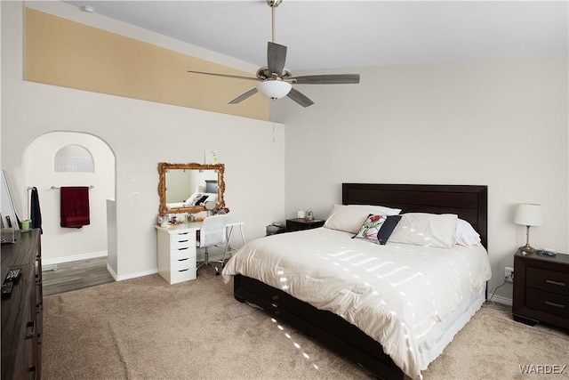 bedroom featuring light carpet, a ceiling fan, and baseboards