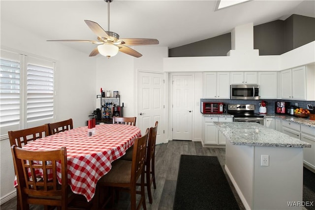 dining room featuring a ceiling fan, lofted ceiling, and dark wood-style flooring