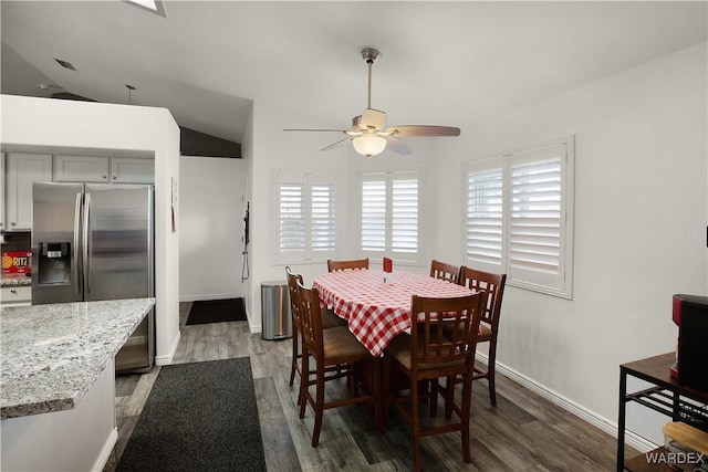 dining area featuring plenty of natural light, baseboards, vaulted ceiling, and dark wood-style flooring