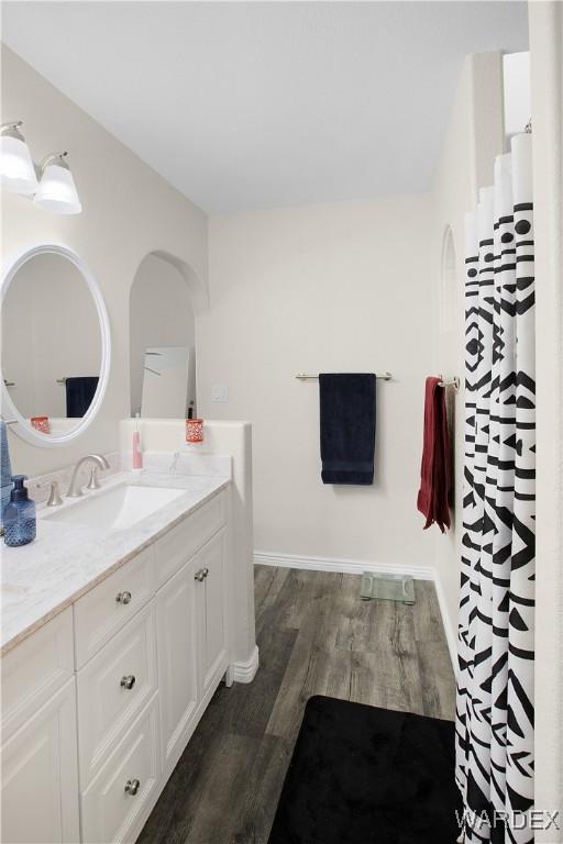 bathroom with vanity, baseboards, and wood finished floors