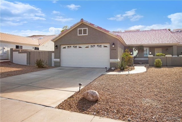 ranch-style house featuring driveway, a tiled roof, an attached garage, fence, and stucco siding