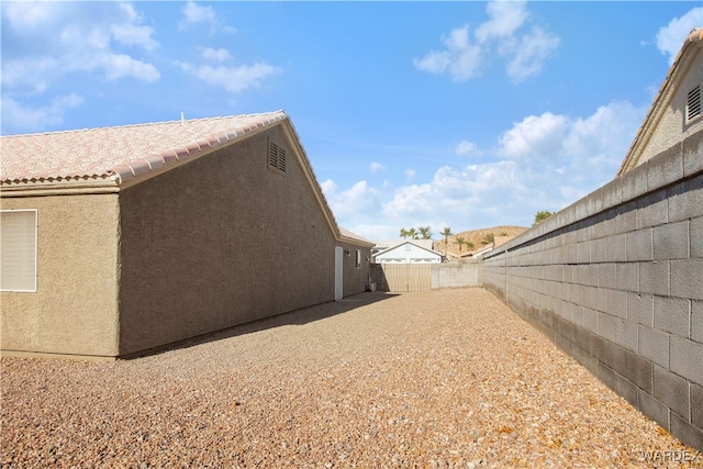 view of home's exterior featuring a tile roof, a fenced backyard, and stucco siding