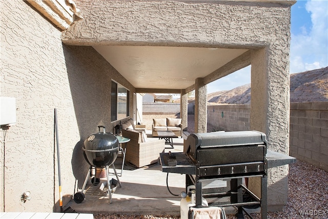 view of patio with a grill, fence, a mountain view, and outdoor lounge area