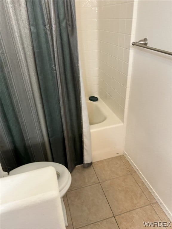 full bathroom featuring tile patterned flooring, baseboards, and shower / bath combo with shower curtain