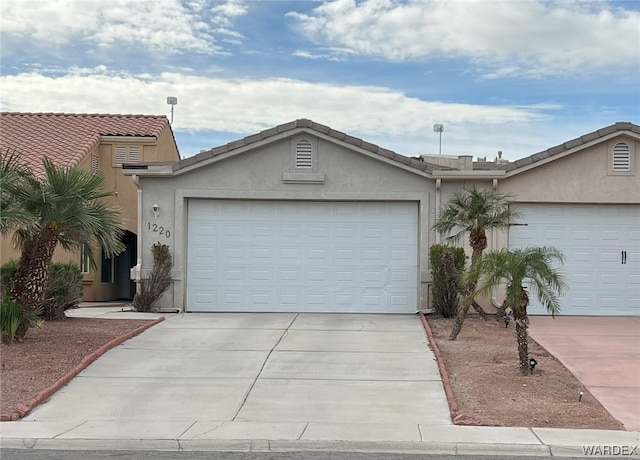 single story home featuring concrete driveway, a tiled roof, an attached garage, and stucco siding