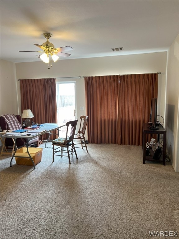 living area featuring visible vents and ceiling fan