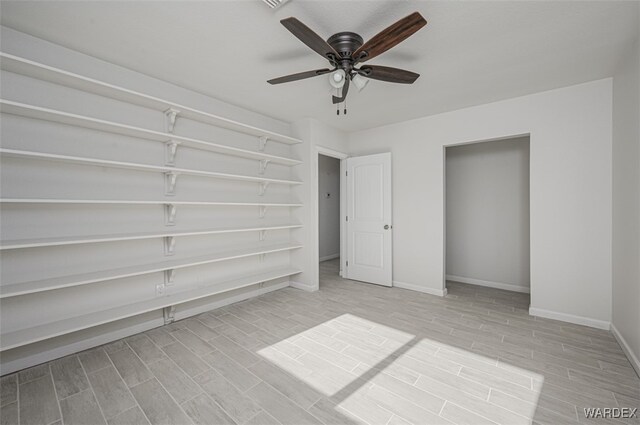 unfurnished bedroom featuring wood finish floors, a ceiling fan, and baseboards