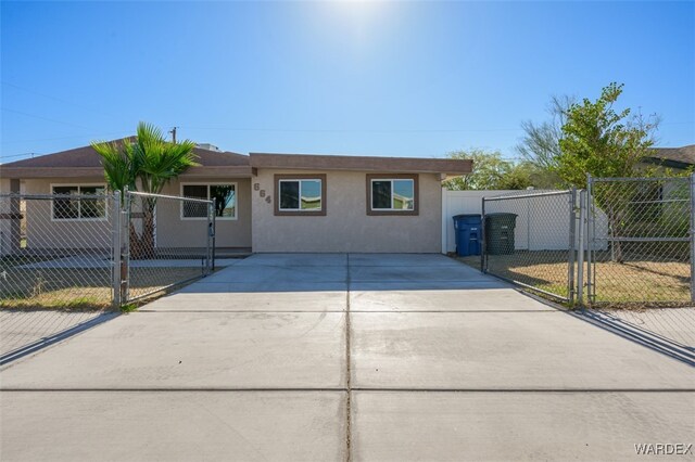 single story home featuring a gate, fence, driveway, and stucco siding