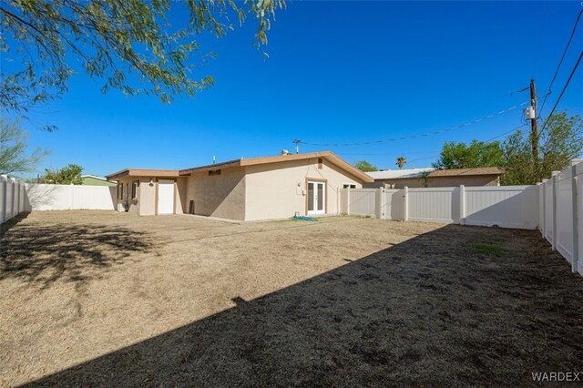 back of property featuring a fenced backyard and stucco siding