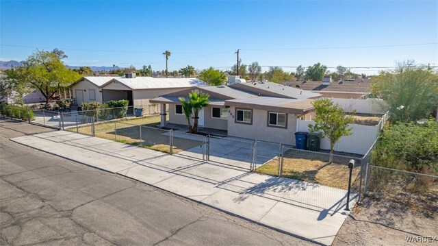 ranch-style house featuring a fenced front yard, a residential view, a gate, and stucco siding