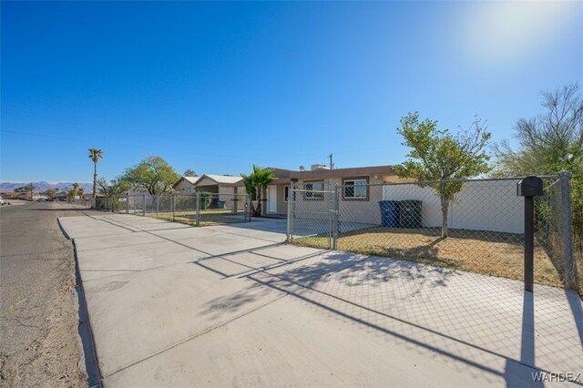 ranch-style house featuring a gate and fence