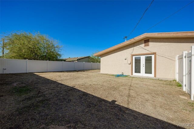 view of yard featuring french doors and a fenced backyard