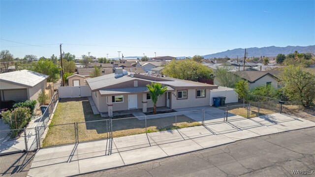 view of front facade featuring a fenced front yard, a residential view, a gate, and a mountain view