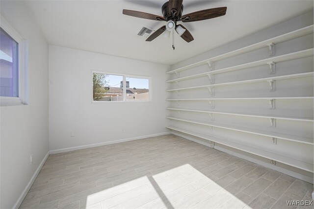 unfurnished room with light wood-style floors, visible vents, and baseboards