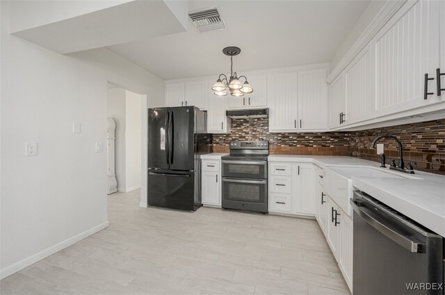 kitchen featuring stainless steel appliances, light countertops, visible vents, a sink, and under cabinet range hood