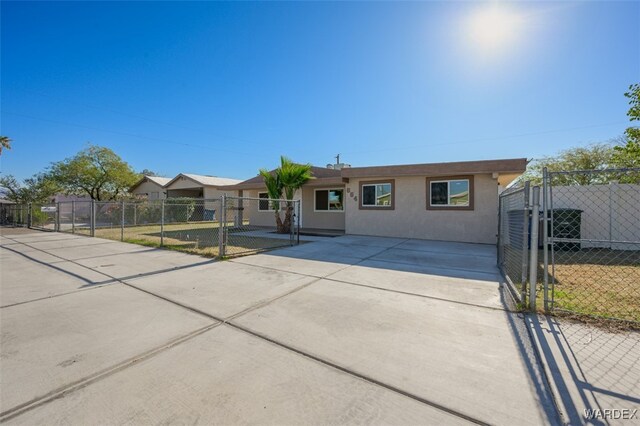 view of front facade with a gate, fence, and stucco siding