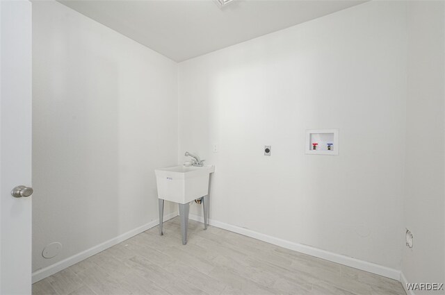 laundry area featuring laundry area, baseboards, light wood-style flooring, hookup for a washing machine, and hookup for an electric dryer