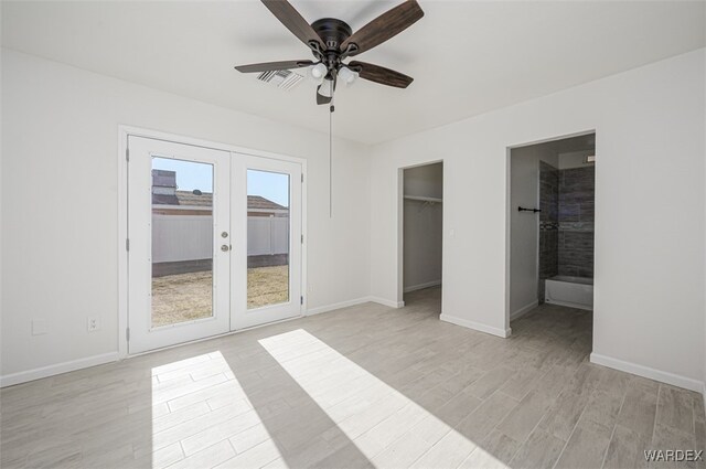 unfurnished bedroom featuring light wood finished floors, visible vents, baseboards, access to outside, and french doors