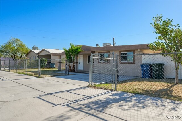 ranch-style home with a fenced front yard and a gate