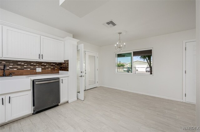 kitchen featuring white cabinets, light countertops, and dishwashing machine