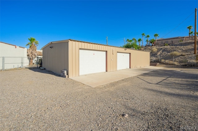 detached garage featuring fence