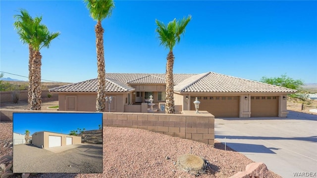 view of front of property with a garage, concrete driveway, a tiled roof, and stucco siding