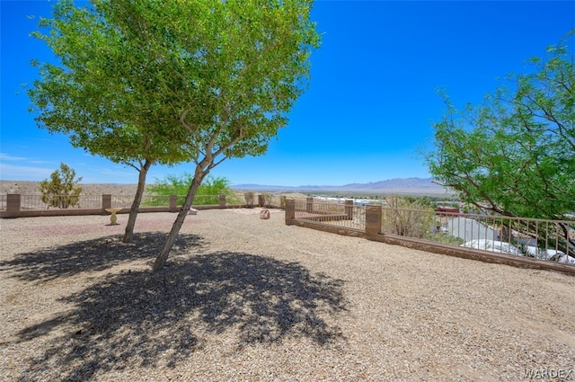 view of yard featuring fence and a mountain view