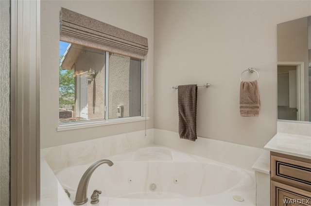 bathroom with a whirlpool tub and vanity