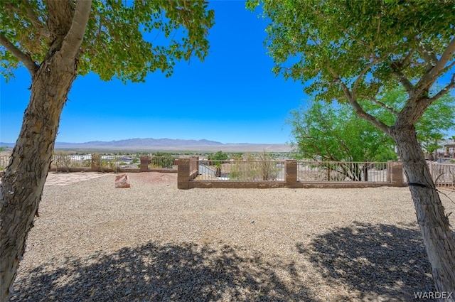 view of yard featuring a mountain view and fence