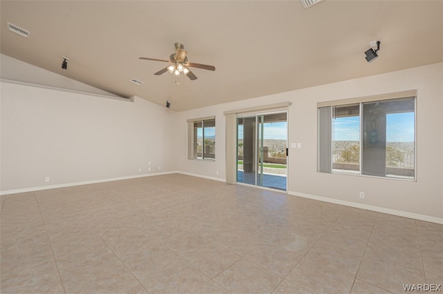 empty room featuring a ceiling fan, lofted ceiling, visible vents, and baseboards