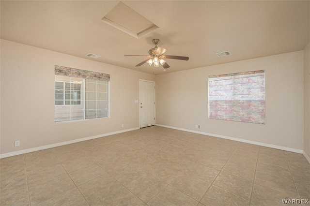 unfurnished room with attic access, visible vents, and baseboards