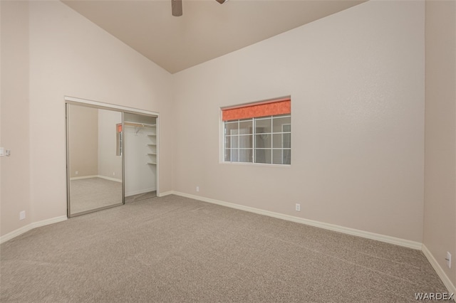 unfurnished bedroom with lofted ceiling, ceiling fan, baseboards, a closet, and carpet